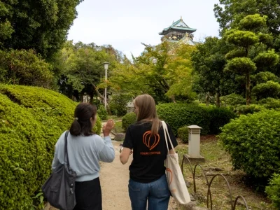Japanilainen opas ja TourCompassin työntekijä kävelevät Osakassa, Japanissa.