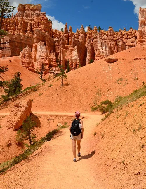 Henkilö kävelee polulla ikonisten oranssien kallioiden välissä Bryce Canyonin kansallispuistossa Utahissa, Yhdysvalloissa.